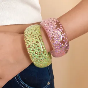 Bracciali rigidi in resina alla moda con inclusioni di scaglie iridescenti colorate.
