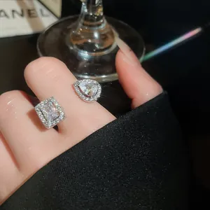 Macro del brillante zircone quadrato e a goccia su un elegante anello aperto