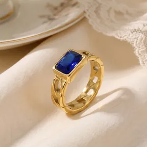 Detailed view of gold stainless steel Cuban chain ring with emerald-cut blue zircon.
