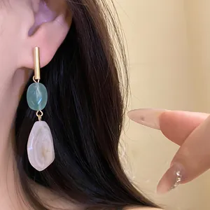 Close-up detail of vintage-style geometric resin drop earrings worn on model's ear