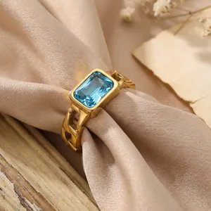 Close-up view of a vintage gold Cuban chain ring featuring a rectangular blue gemstone