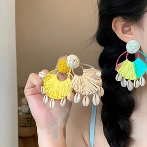 Orecchini bohémien in rafia con ciondoli a conchiglia per uno stile da spiaggia.