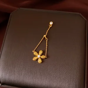 Primo piano di un anello a fiore dorato regolabile con accenti di zirconi luccicanti.