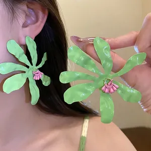 Oversized green crinkle flower drop earrings with a pink center for a summer vacation look.