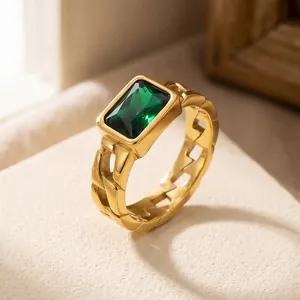 Close-up of vintage golden Cuban chain ring featuring a large rectangular green zircon.