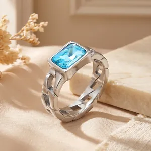 Detailed macro view of silver-tone chain ring with a rectangular blue zircon stone