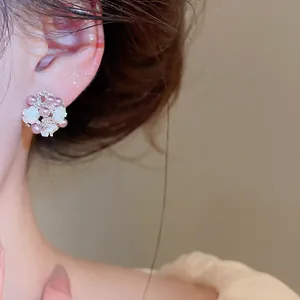 Elegant French-style flower pearl stud earrings for women, close-up on model's ear