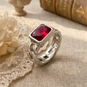 Close-up of vintage stainless steel Cuban chain ring with a large red zircon stone.