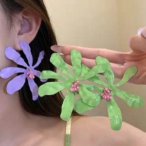 Detail of vibrant drip oil wrinkled flower earrings on a model in vacation style