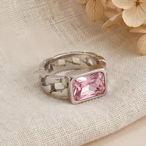 Close-up detail of a silver stainless steel Cuban link ring with a pink gemstone