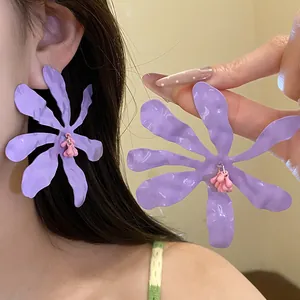 Close-up of purple wrinkled flower earrings with pink beaded pendant detail