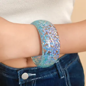 Dettaglio ravvicinato di un bracciale in resina iridescente con frammenti blu brillanti