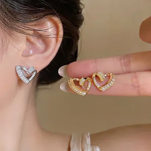 French style twisted heart stud earrings with zircons in gold and silver colors.