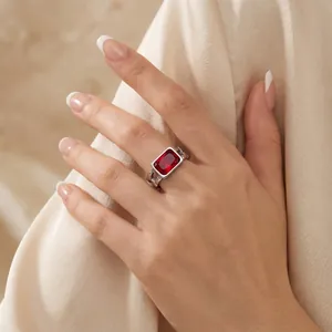Macro view of a vintage square red zircon ring on a hand, silver titanium steel band