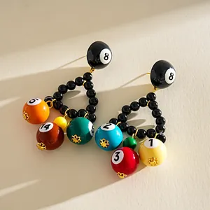 Close-up detail of colorful resin billiard ball triangle drop earrings with black beads