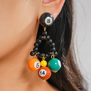Close-up view showing the detail of unique colorful billiard ball triangle drop earrings on model