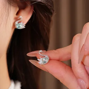 Elegant silver swan stud earrings featuring light blue zircon and sparkling crystals