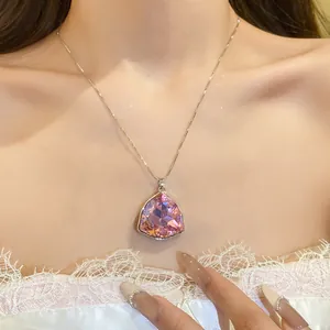 Dettaglio di una collana di lusso con pendente a triangolo in cristallo rosa su modella