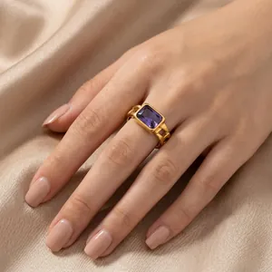Close-up detail of a vintage gold-toned Cuban chain ring with a purple gemstone