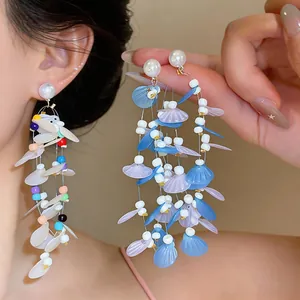 Close-up detail of ethereal long tassel earrings featuring pearls and colorful sequins