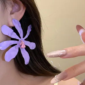 Detail shot of a large purple wrinkled flower earring with a pink center for resort style
