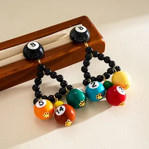 Macro view of colorful resin billiard ball triangle drop earrings with silver pins.