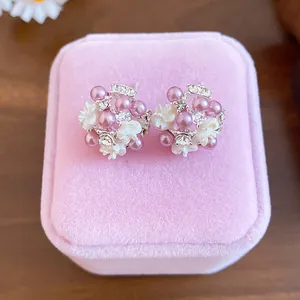 Macro view of elegant flower cluster stud earrings with pink pearls and crystals