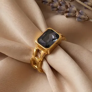 Macro detail of a vintage gold-plated Cuban link ring featuring an emerald-cut black zircon