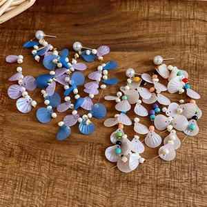 Macro view showing shell-shaped sequins and colorful bead details on tassel earrings