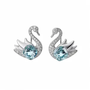 Elegant silver-tone swan stud earrings featuring light blue crystals and white zircons.