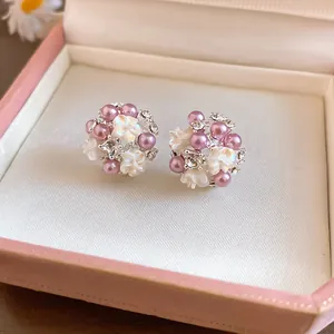 Close-up of French floral cluster stud earrings with purple pearls and crystals