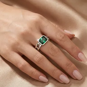 Detailed view of a vintage Cuban link ring featuring an emerald cut green gemstone
