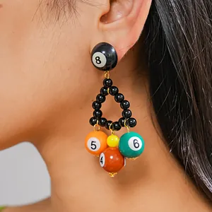 Close-up detail shot of colorful resin billiard ball triangle drop earrings being worn