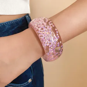 Vista dettagliata di un bracciale in resina trasparente con glitter rosa iridescenti