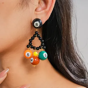 Detailed close-up of a vibrant resin billiard ball triangular drop earring on model's ear