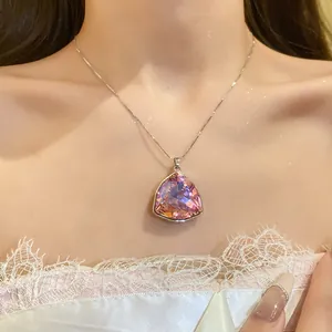 Primo piano di una collana con ciondolo a triangolo in cristallo rosa e argento