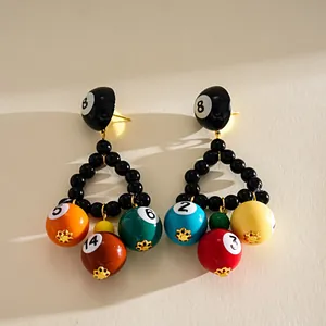 Detail view of colorful resin billiard ball triangle earrings featuring vibrant digital numbers