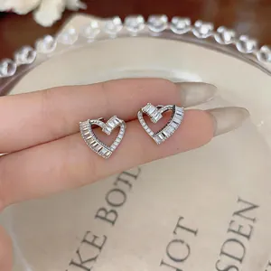 A detailed macro view of elegant twisted heart stud earrings with cubic zirconia stones