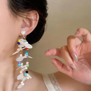 Detailed shot of long sequin tassel earrings with colorful beads and pearl studs