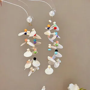 Elegant vacation style dangle earrings with colorful beads and white shell petal details.