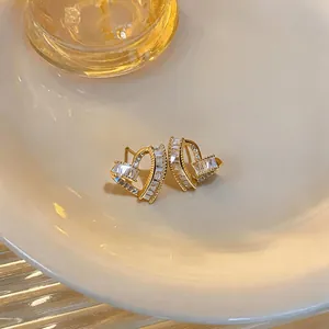 Close-up of French luxury twisted heart stud earrings with sparkling baguette zircons