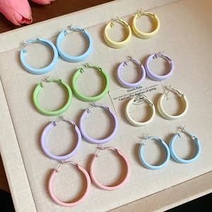 Macro view of multiple colorful dopamine-inspired hoop earrings in various pastel shades