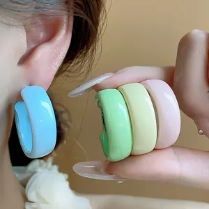 Close-up of dopamine colored painted hoop earrings in blue, green, yellow, and pink