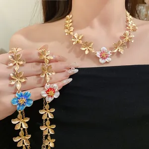 Dettaglio ravvicinato di collana e bracciale vintage con fiori in metallo smaltato