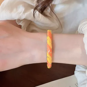 Vue rapprochée d'un bracelet doré de style chinois moderne porté sur un poignet