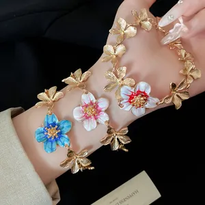 Vista dettagliata del set collana e bracciale vintage con fiori in smalto oro