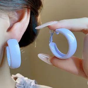 Close-up of light purple thick hoop earrings featuring a smooth spray-painted finish.