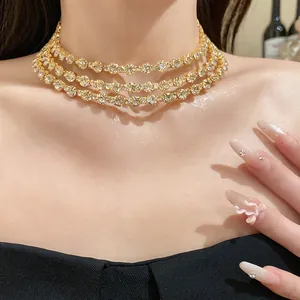 Close-up detail of an elegant three-layer golden rhinestone choker necklace on a model's neck.