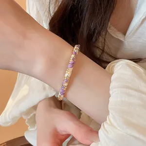 Gros plan d'un jonc en émail doré de style néo-chinois avec des motifs floraux