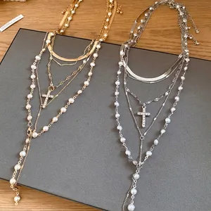 Layered pearl bead necklace with a sparkling rhinestone cross pendant in gold and silver